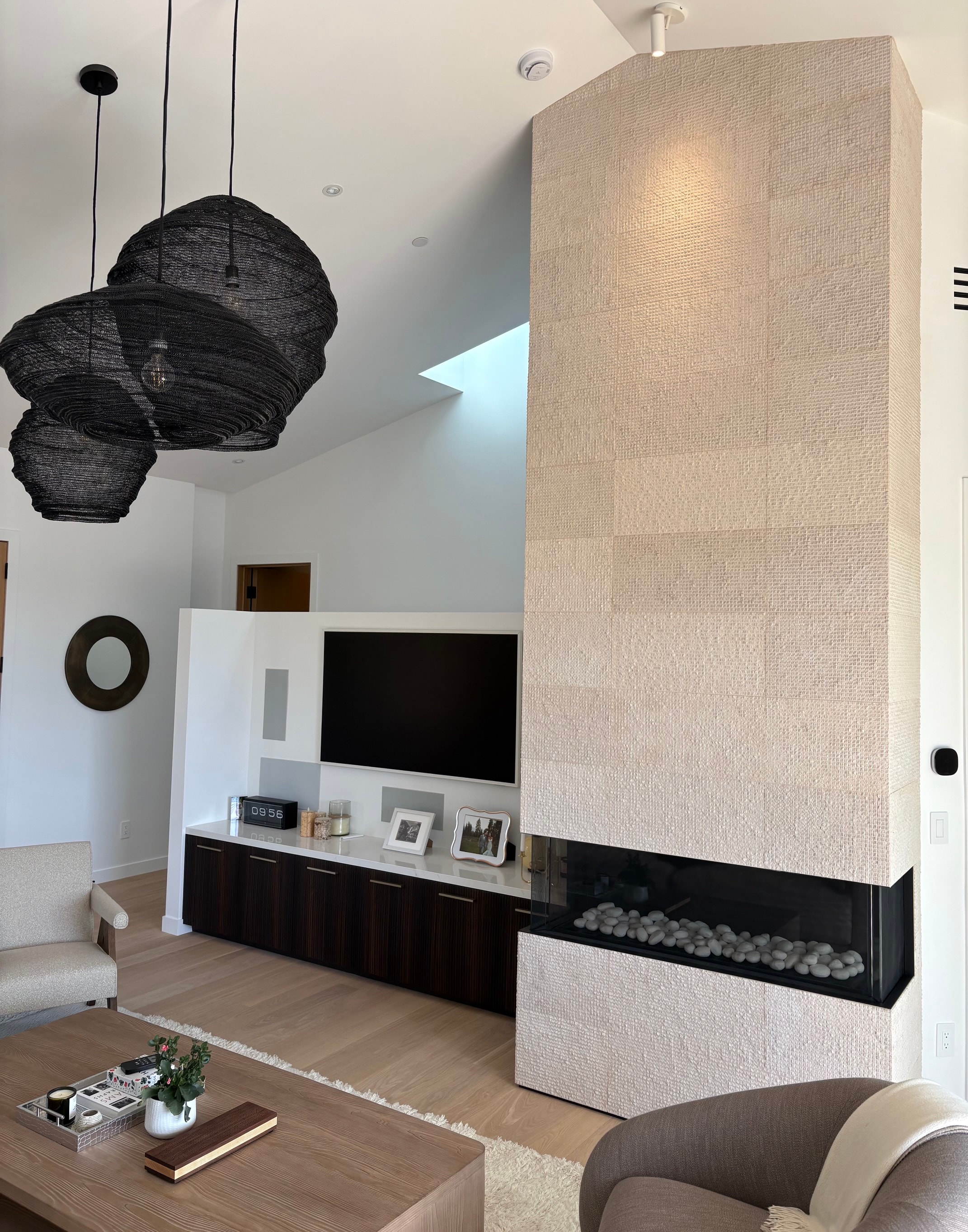 Contemporary living room with sculptural pendant lighting and a fireplace